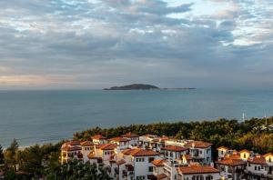 三亚Sanya Summer Beach Sea View Hotel的海边山丘上的一群房子