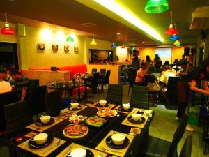 Ban Kaeoเมล่อนลอยฟ้า的餐厅设有餐桌,上面放有食物盘