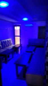 OshodiAmericana Hotel的一间紫色灯、桌子和沙发的房间