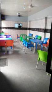 OshodiAmericana Hotel的用餐室配有色彩缤纷的桌椅
