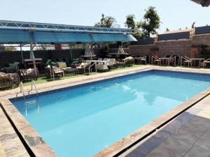 阿奴古Easton Hill Continental Hotel的一个带桌椅的大型蓝色游泳池