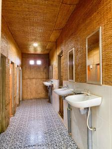 芹苴Hometravel Mekong Can Tho的浴室设有3个水槽和2面镜子