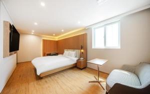 庆州H Avenue Gyeongju的酒店客房,配有床和电视
