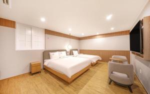 庆州H Avenue Gyeongju的一间卧室配有一张大床和一台平面电视