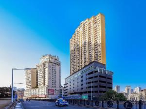 贵阳Echarm Hotel Guiyang Zhongshan West Road Metro Station的街道上拥有高楼和汽车的城市