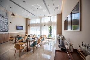 QuelingzuiCity Comfort Inn Ezhou Wuyue Plaza的一间在房间内配有桌椅的餐厅