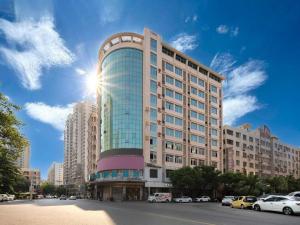 晋江City Comfort Inn Quanzhou Jinjiang Airport Yangguang Food Street的太阳照耀着的一座高楼