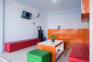 LaweanUrbanview Syariah Wisma Nabil Solo的一间设有红色和绿色座椅和桌子的房间
