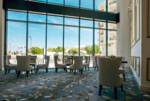 多哈Royal sherao hotel فندق شراعوه الملكي的一间设有椅子和桌子的等候室,窗户