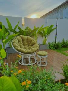 Buôn Alê (1)Nha Trong Pho - The Chilling House的种有植物的庭院里的椅子和凳子