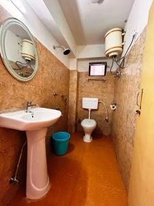 佩林DISHA SILVER PEAK Hotel的一间带水槽和镜子的卫生间的浴室