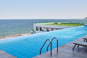 北马马亚-讷沃达里RoseBay std - Infinity Pool & Spa Resort的一座背景海洋的游泳池