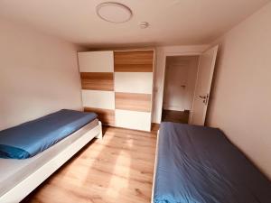 明登Ferienwohnung/Monteurwohnung Souterrain, neu renoviert的一间小卧室,配有两张床和一个衣柜