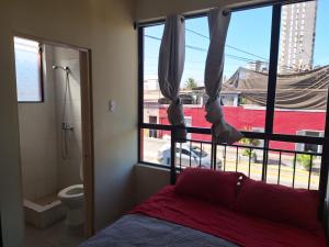 伊基克Hotel San Felipe Iquique的一间卧室设有一张床、一个窗口和一个卫生间