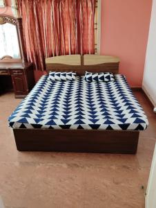钦奈Happy Beach House的一张带蓝色和白色床垫的床