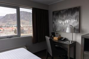 坎卢普斯汤普森酒店的酒店客房设有一张桌子、一张床和一个窗户。