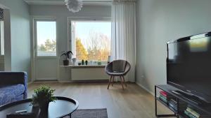 万塔Green Getaway - near Helsinki Vantaa Airport, top-floor, free parking & wifi的客厅配有电视和椅子