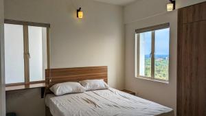 特里凡得琅Lake and sea facing 2BHK with ultimate privacy的一间卧室设有一张床和两个窗户。