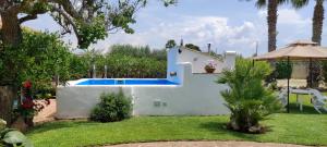 马尔萨拉Casa Vacanze ANTICO CASALE的一座白色的房子,在院子里设有游泳池
