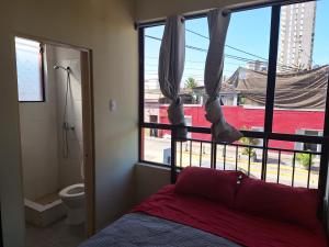 伊基克Hotel San Felipe Iquique的一间卧室设有一张床、一个窗口和一个卫生间