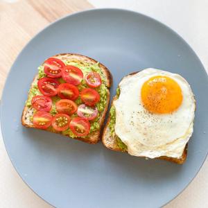 古尔冈Staykr Rooms & BnB的蓝盘烤面包上的鸡蛋和西红柿