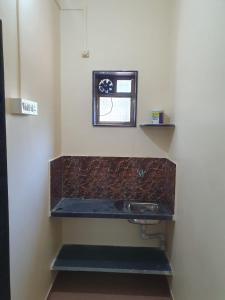 MiryaSWAMI HOMESTAY的一间带水槽和镜子的浴室以及窗户。
