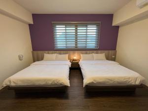 集集镇沐乐旅舍 ML.b&b的紫色墙壁客房的两张床