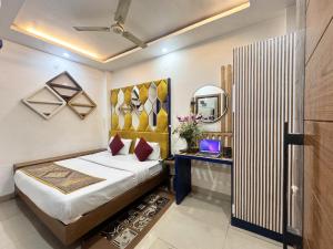 新德里Staybook Hotel Jai Balaji, Paharganj, New Delhi Railway Station的一间卧室配有一张床、一张书桌和一面镜子