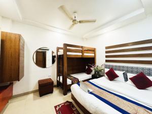 新德里Staybook Hotel Jai Balaji, Paharganj, New Delhi Railway Station的一间卧室配有两张双层床和镜子