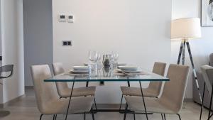 贝尼多姆SUNSET WAVES luxury apartment的餐桌、椅子和玻璃桌