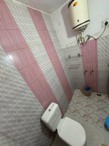奈尼塔尔Nature's Vibe Homestay - Nainital - Kainchi Dham的一间带卫生间和粉红色墙壁的浴室
