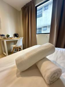 吉隆坡Swing & Pillows - KL Pekeliling formerly known as Swiss Cottage Hotel的在酒店客房内的床上的毛巾