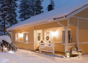 罗瓦涅米Arctic Circle Home close to Santa`s Village的雪中的房子,灯亮