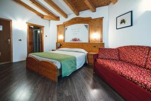 马洛斯科Hotel Bel Soggiorno的一间卧室配有一张床和一张沙发
