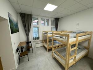 卡托维兹Green Hostel Katowice 24h - Free Parking的客房设有三张双层床和一张书桌。
