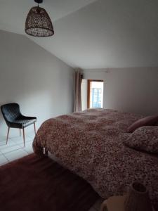La Chapelle-aux-BoisLa Mansarde的卧室配有床、椅子和窗户。