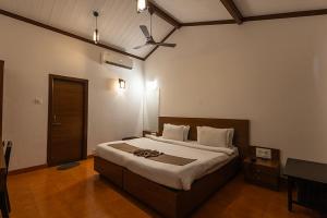 马泰兰Scarlet Resort的一间卧室配有一张大床和吊扇