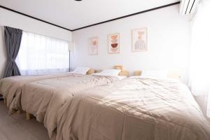 冈山Lino下伊福的白色卧室设有两张床和大窗户