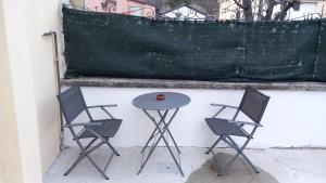 桑格罗堡il Biscottino的墙上有两把椅子和一张桌子