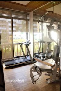 马尼拉Spacious 2BR + FAST WIFI 200mbps PLDT Fiber的健身房设有两辆健身自行车和窗户