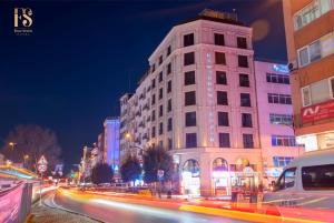 伊斯坦布尔FOUR SEVEN HOTEL的夜幕降临的城市街道上一座高楼