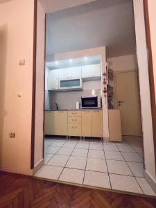 布德瓦Apartment Babin do的厨房配有白色橱柜和瓷砖地板。