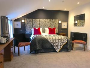 斯卡伯勒和里钠酒店的一间卧室配有一张带红色枕头的大床