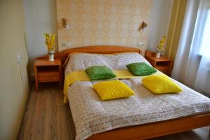 叶卡布皮尔斯Comfortable 4-Room Apartments in Jekabpils的一间卧室配有一张带黄色和绿色枕头的床