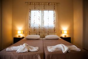 拉基索拉Gerasimos Dream House - 7 Minutes from the Airport的一间卧室配有两张带毛巾的床