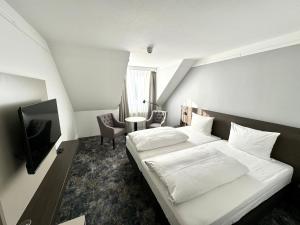 明登明登林佳特酒店 的卧室配有白色的床和电视