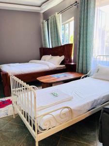 NarokOLENG'OTI GARDENS的一间卧室设有两张床、桌子和窗户。