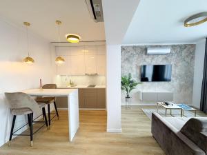 艾格扎洛克Salt Hill Premium Apartments的厨房以及带桌子和沙发的客厅。