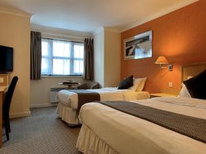 史云顿The Wiltshire Hotel, Golf and Leisure Resort的酒店客房设有两张床和电视。