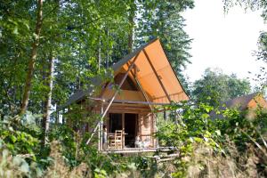 瑟农什Village Huttopia Senonches - Perche的树林中一座树屋,屋顶橙色